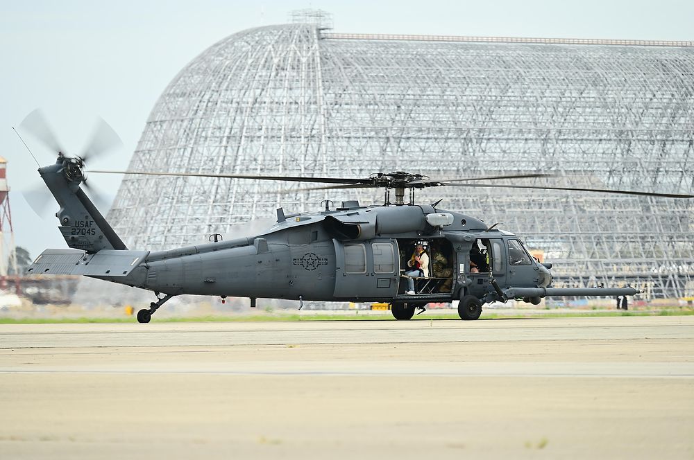 Gray helicopter with woman in passenger seat.