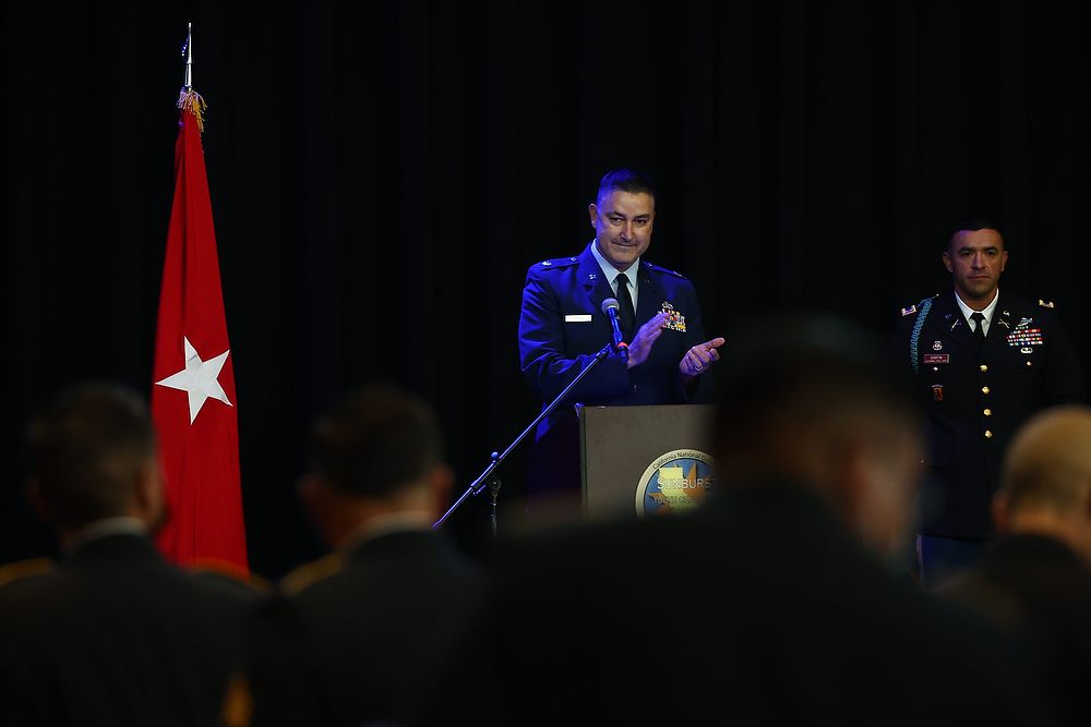 Airman in uniform claps at podium.