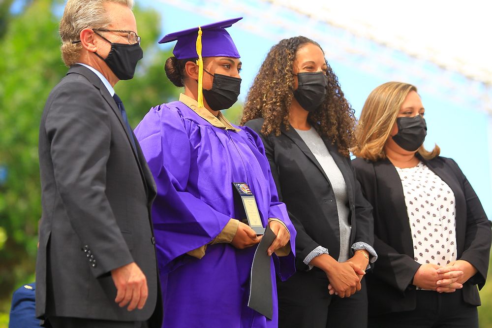High school graduate receives award plaque.