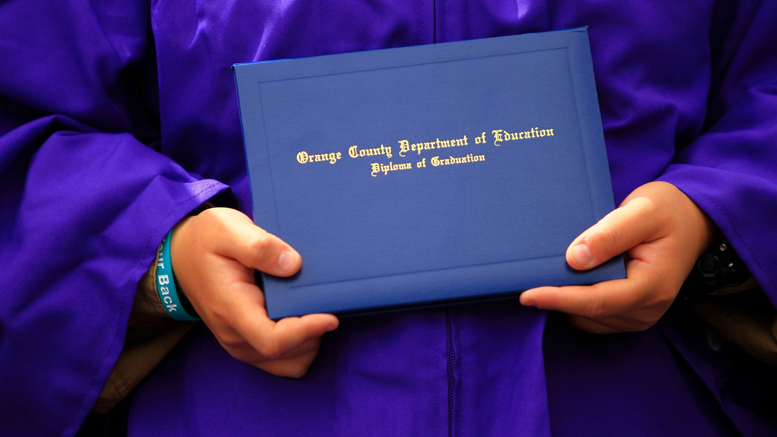 Student holds diploma cover.