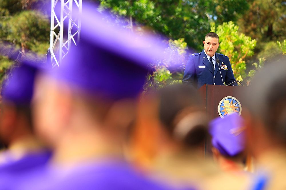 Man in uniform speaks from podium.