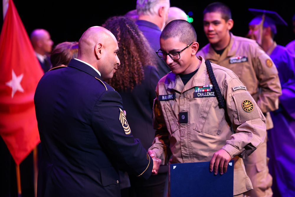 Sunburst Youth Academy commandant congratulates high school teen graduate.