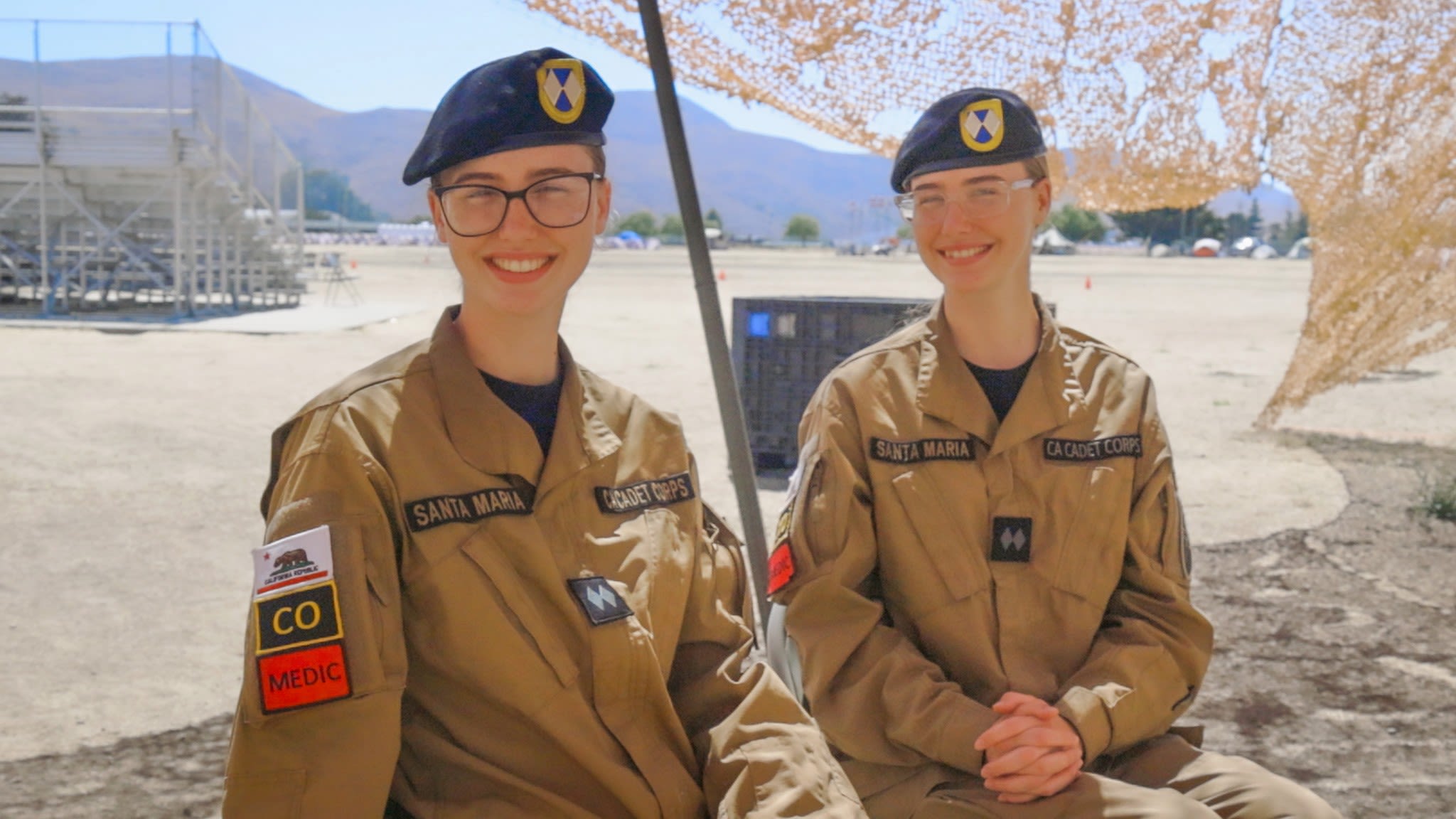 Twin girls in cadet uniforms sit together