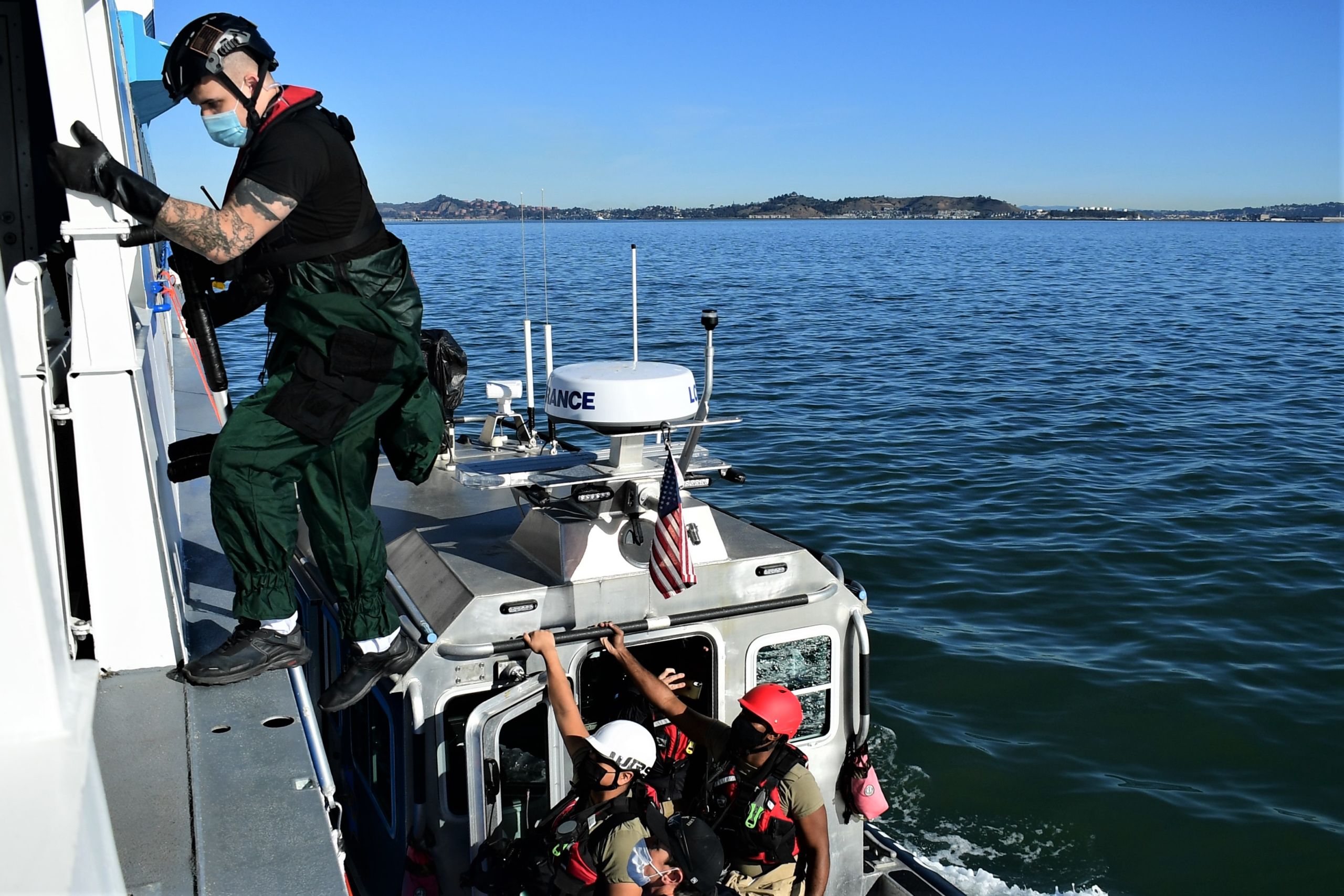 Servicemembers board onto a ferry from a San Francisco Police Department patrol boat.