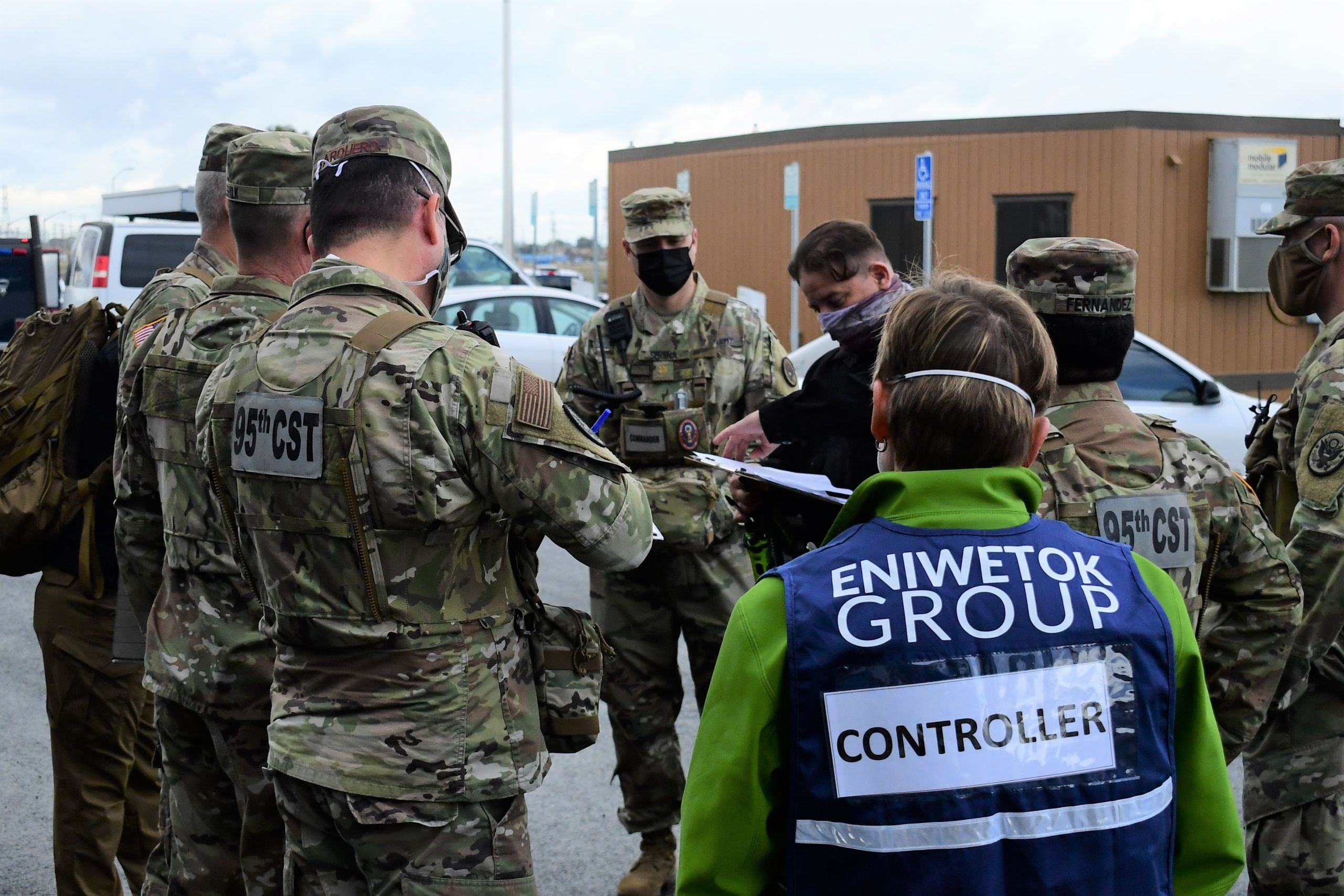 Soldiers and civilians huddle together to discuss strategy.