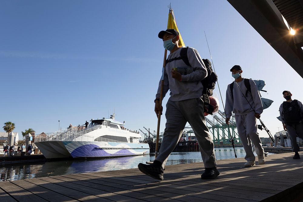 Teen carries flag to boat.