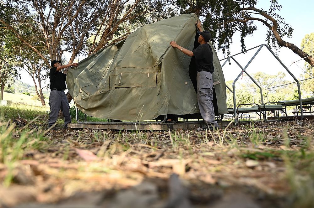 Teens set up a tent.