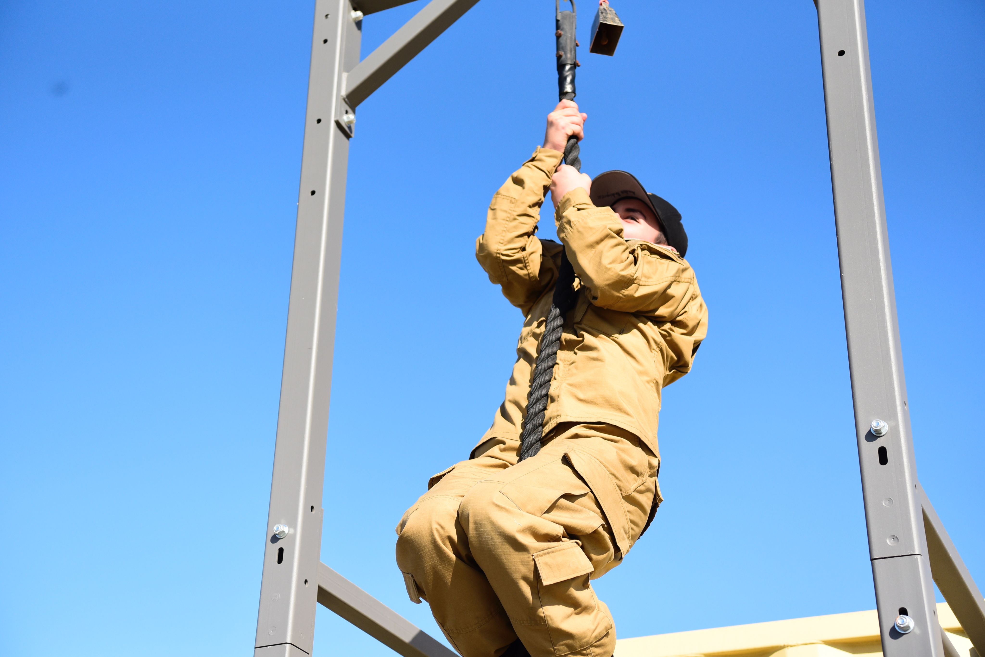 A Cadet climbs a rope.