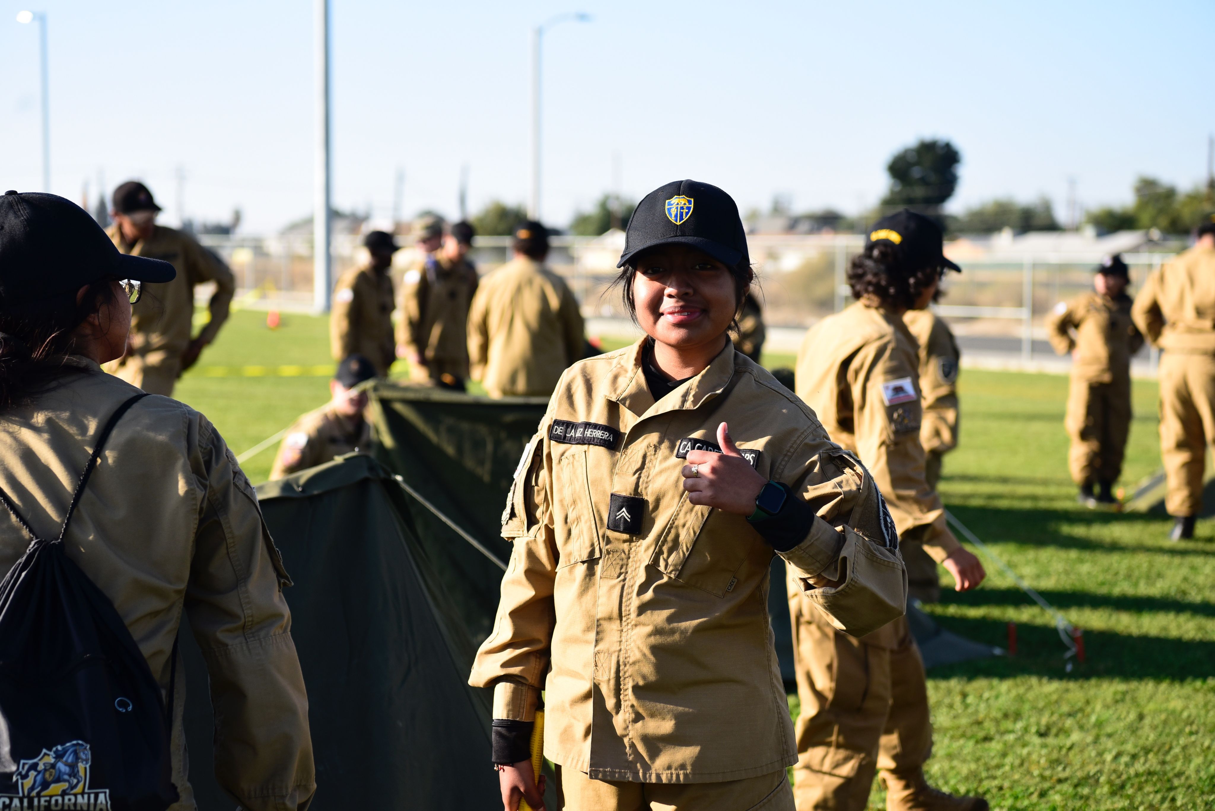 A cadet poses with a thumbs up.